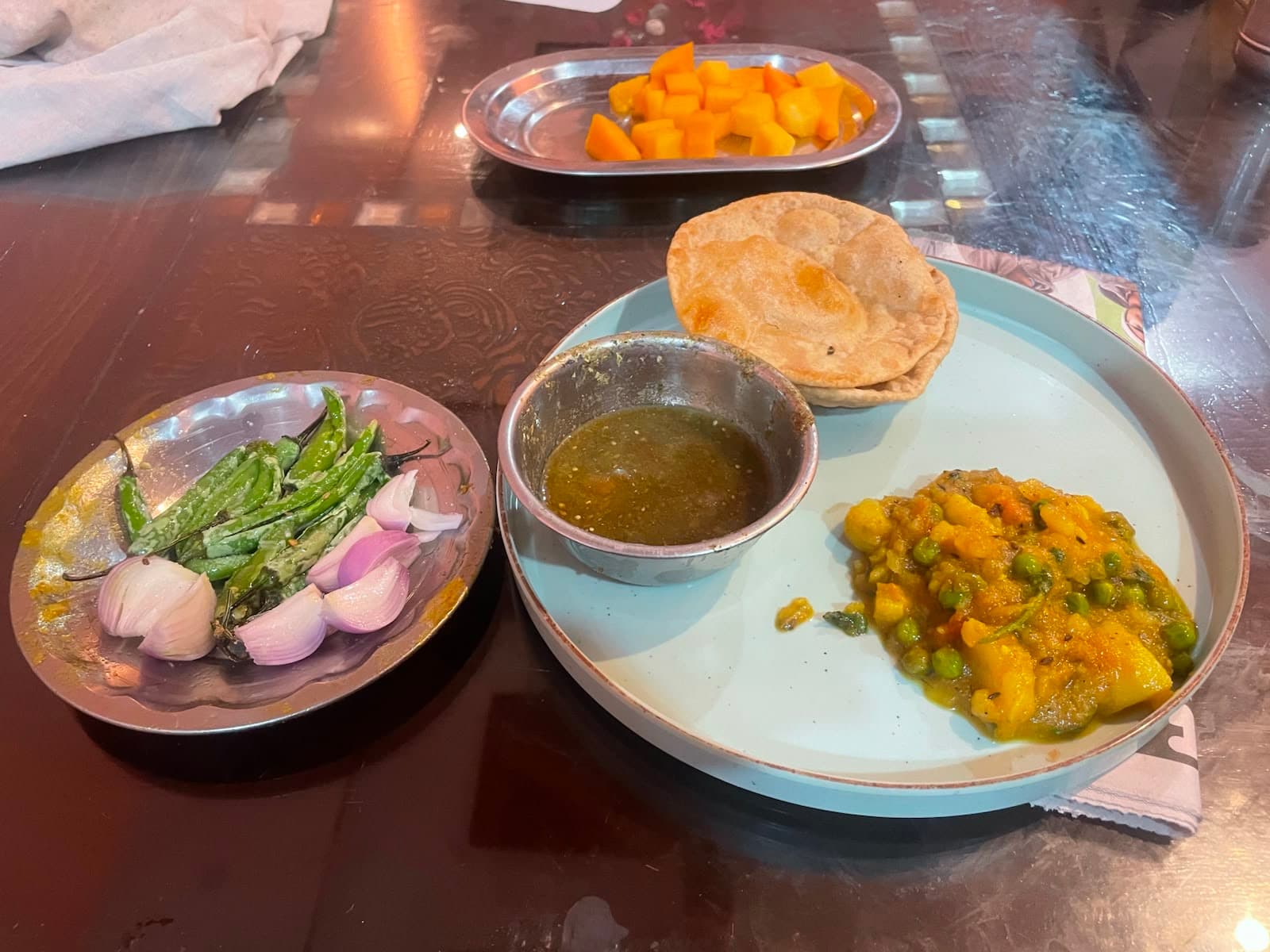 Home-cooked Indian breakfast — puri, aloo sabzi, green chutney and fresh mango